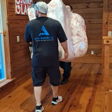 Movers handling wrapped furniture