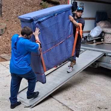 Movers using straps to move heavy item