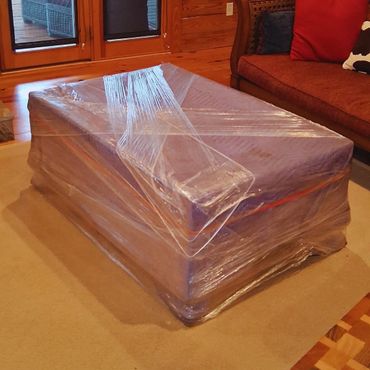 Antique wrapped in a moving blanket and plastic wrap