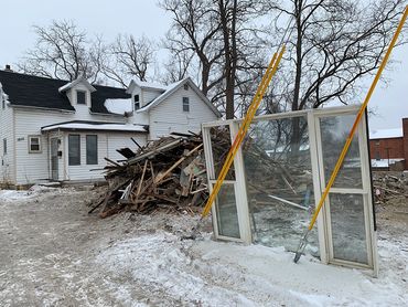 Reclaimed lumber to be culled and processed, along with a salvaged window following deconstruction.