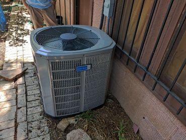 Outdoor air conditioning unit next to a house wall.