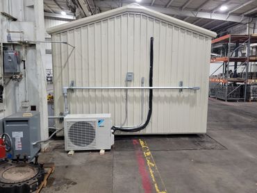 Industrial air conditioning unit and electrical setup inside a warehouse.
