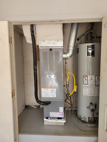 Heating and water heater system installed in a utility closet.