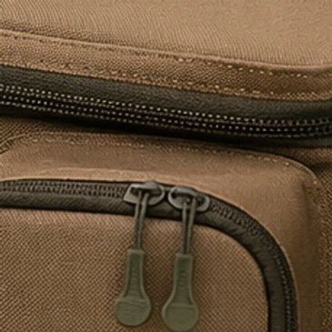 Close-up of brown fabric bag with two zippers.