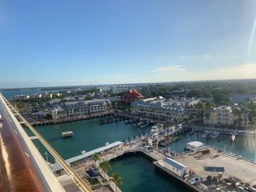 A sunny harbor view with docks and buildings under a clear blue sky.