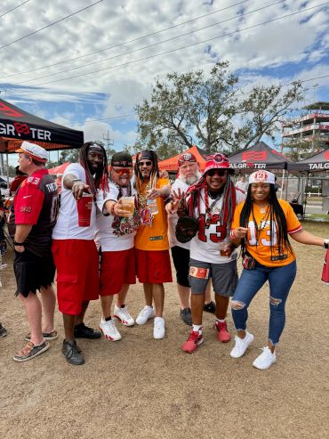 Group of sports fans posing happily outdoors in team colors.