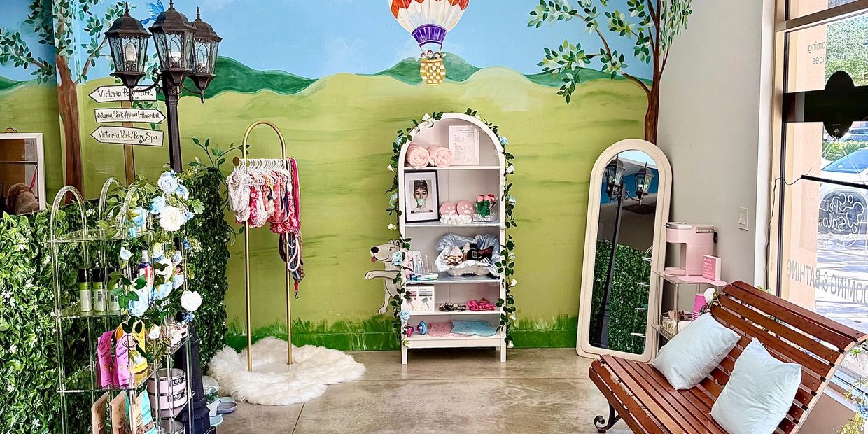 Cozy pet spa corner with greenery, shelving, and a bench.
