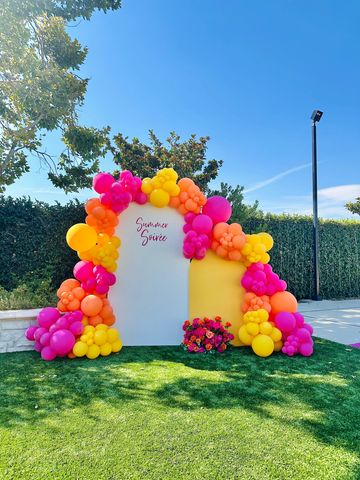 Colorful balloon arch with a summer theme backdrop.