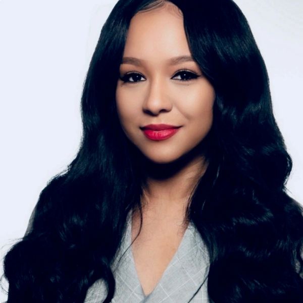 Smiling woman with long black hair and red lipstick.