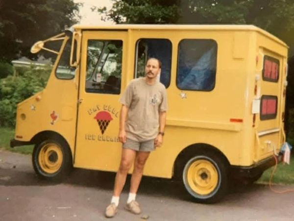 A male entrepreneur standing in front of his novelty ice cream truck