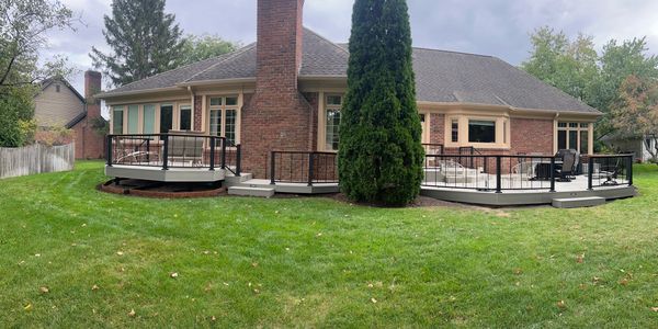 Suburban backyard with raised decks and green lawn.
