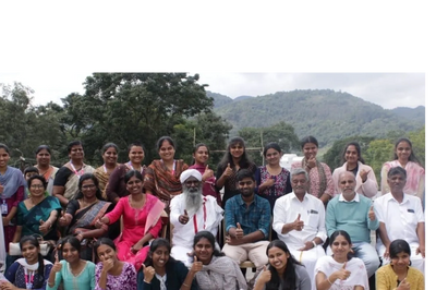 Group photo of diverse people outdoors giving thumbs up with hills in the background.