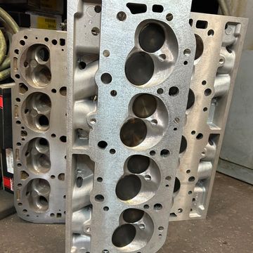 Engine cylinder heads stacked on a workshop floor.