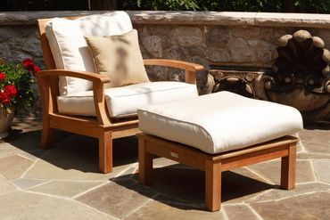 teak lounge chair and ottoman with off white sunbrella cushions on sunny patio