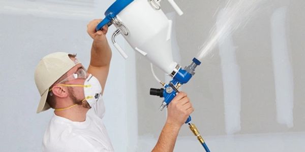 Person applying drywall texture in the ceiling