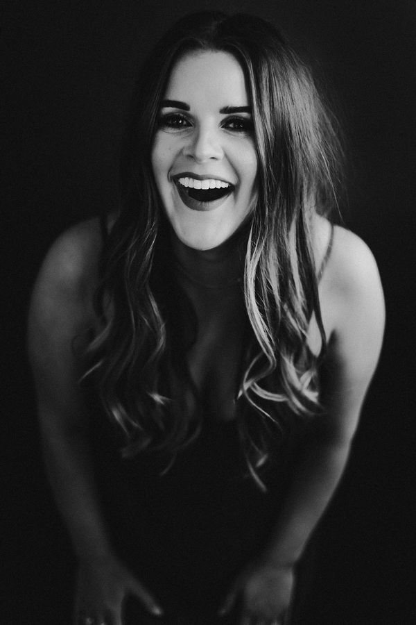 Black and white portrait of a joyful woman laughing.