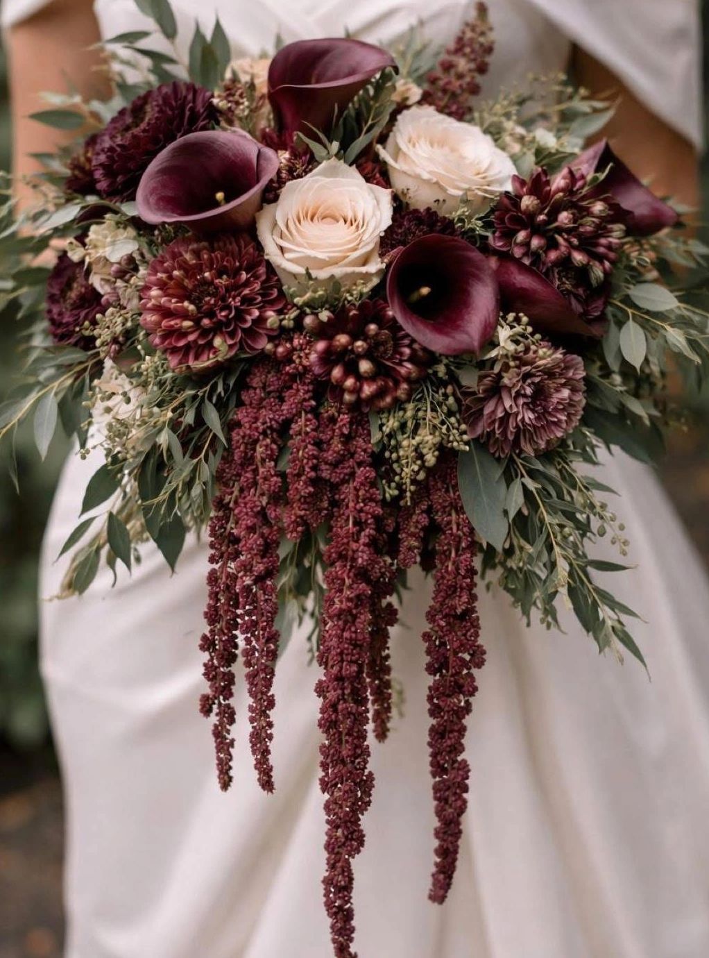 Elegant bridal bouquet with deep burgundy and cream flowers.