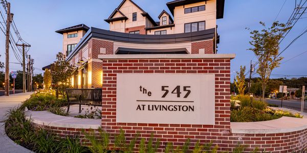Sign for The 545 at Livingston residential building during dusk.