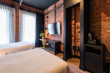 Cozy hotel room with exposed brick walls and modern decor.