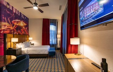 Modern hotel room with a music-themed mural and cozy lighting.