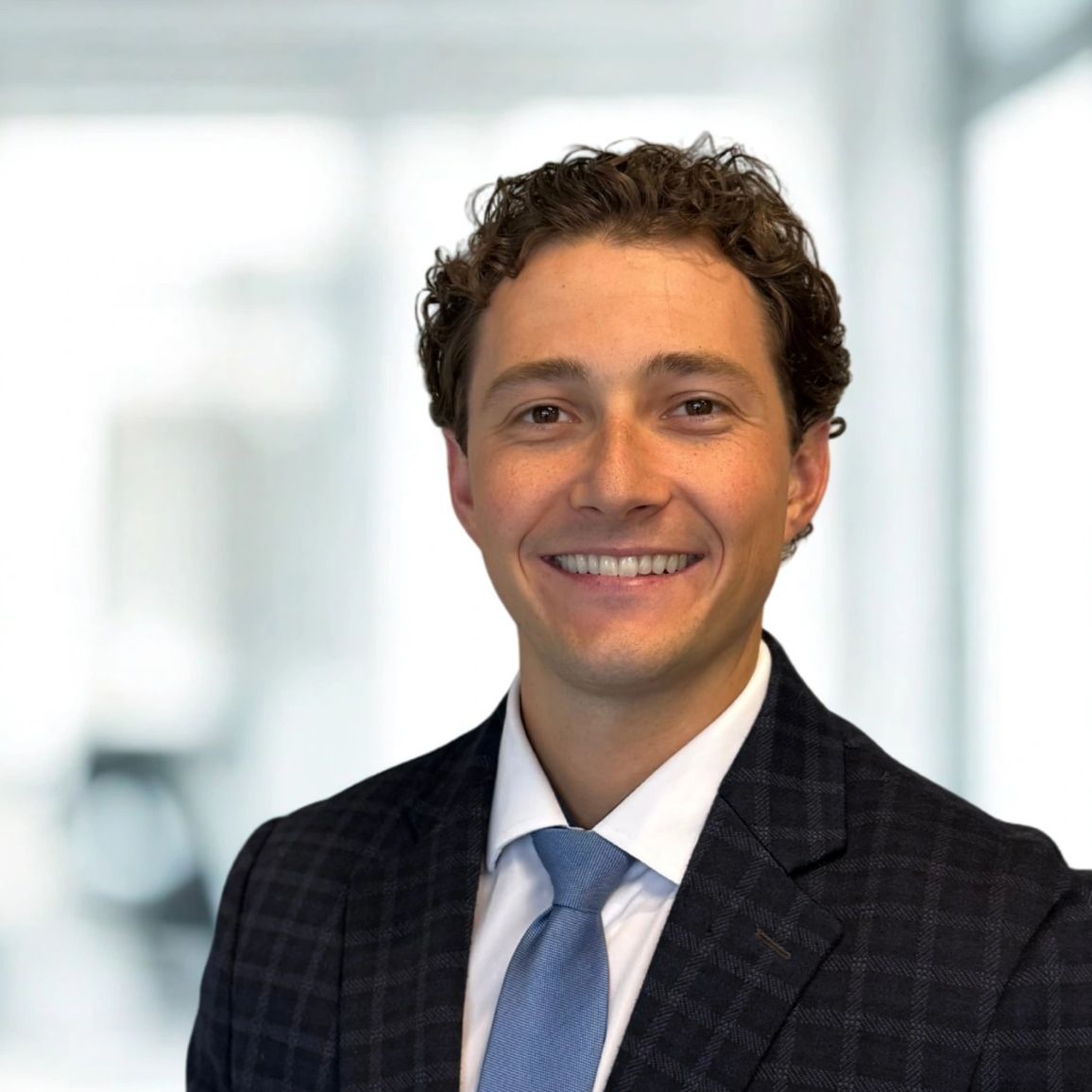 Young man in a business suit smiling.