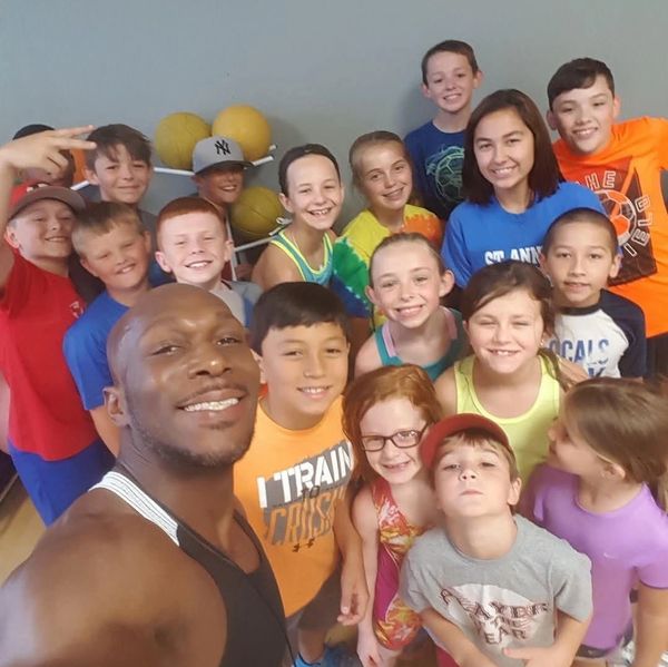 Reggie Jackson taking a selfie with a large group of smiling kids.