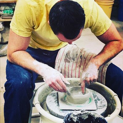 Adult student working with clay on a pottery wheel at Artyard Studio in WNY