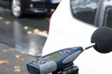 A microphone mounted on a bike handlebar on a wet street.