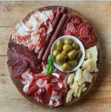 Thin slices of four types salami and prosciutto, with fruit, olives, and crackers