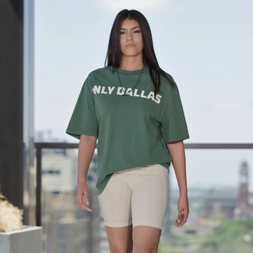 A woman wearing a green ONLY DALLAS T-shirt