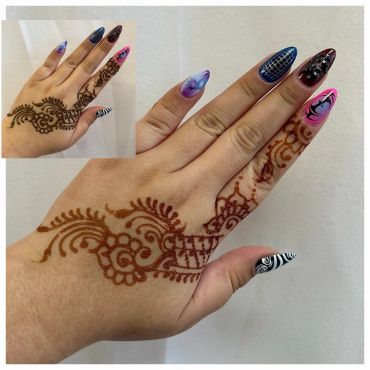 Hand with henna design and colorful, patterned nails.