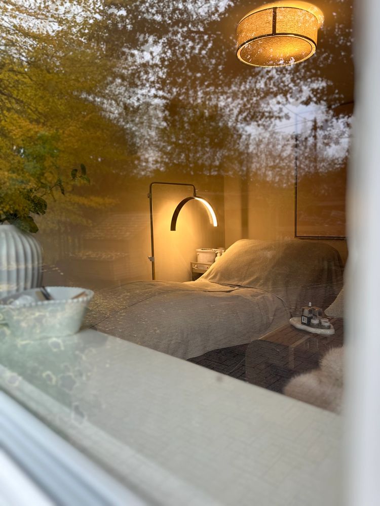 Cozy bedroom with warm lighting and autumn reflections.
