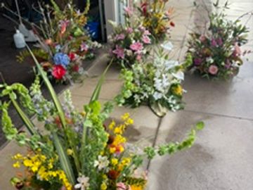 Four colorful flower arrangements on the floor.