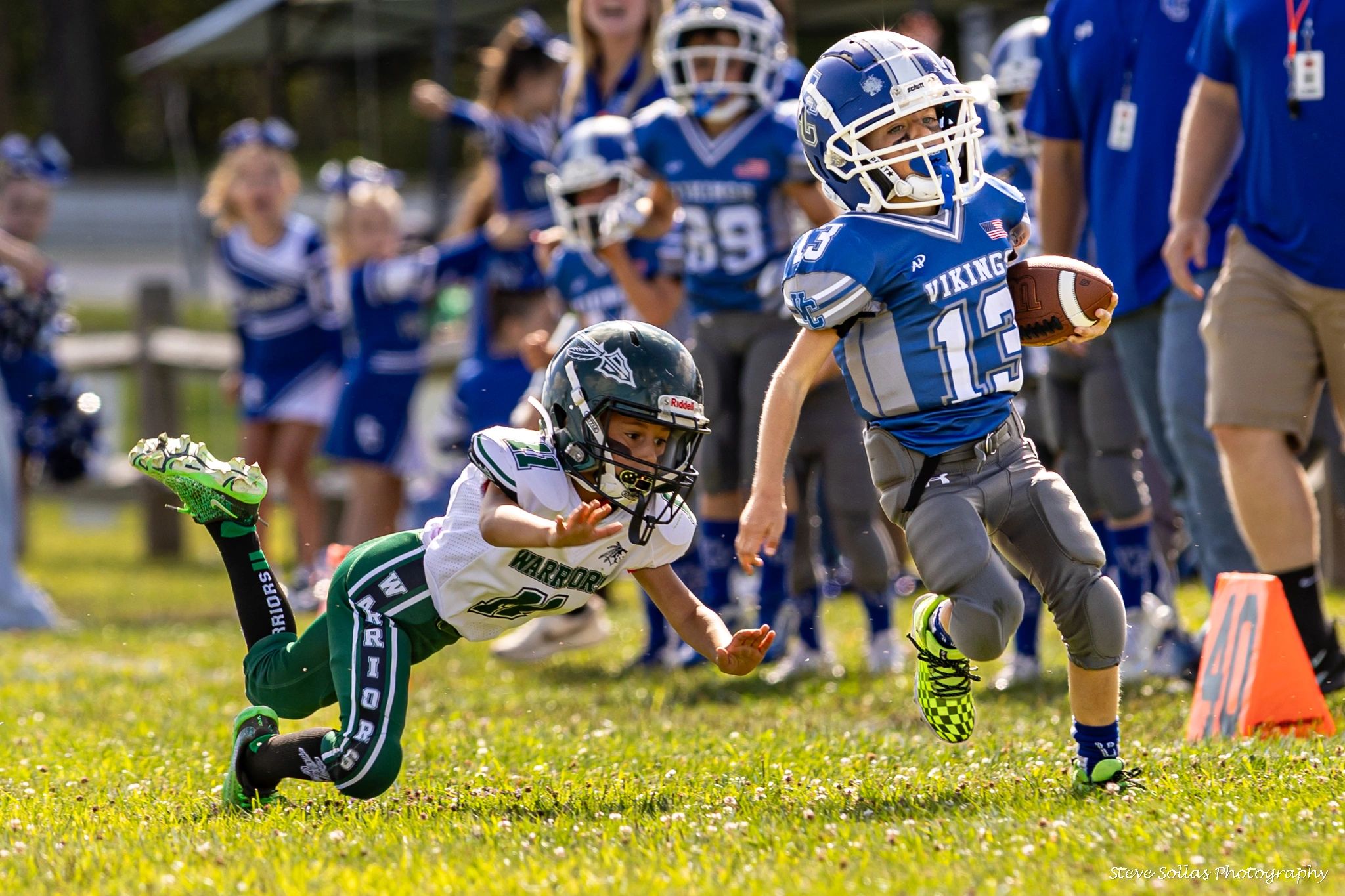 Youth football player dodges a tackle during an intense game.