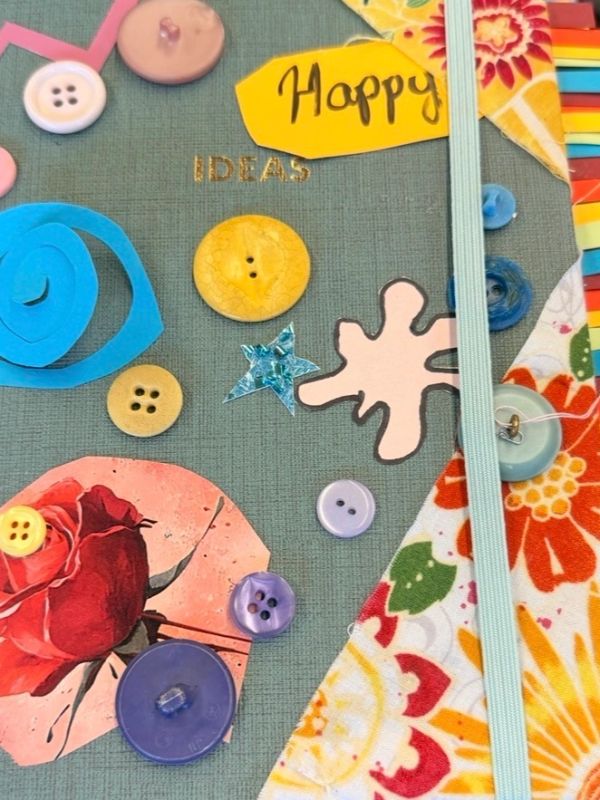 Colorful craft buttons and decorations on fabric.