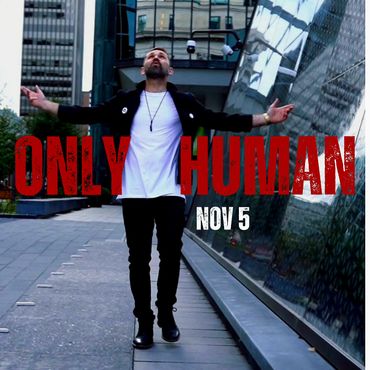 Man with arms outstretched in urban setting, text 'Only Human Nov 5'.