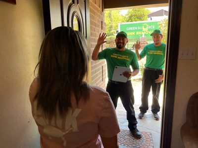 Green Source Junk Removal employees greeting customer.