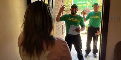 Green Source Junk Removal employees greeting customer.