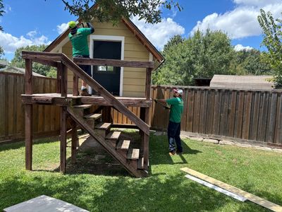 Green Source Junk Removal team demolishing a playhouse in Bedford, TX