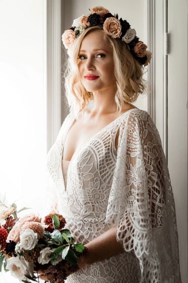 Bride in lace dress with floral crown and bouquet.
