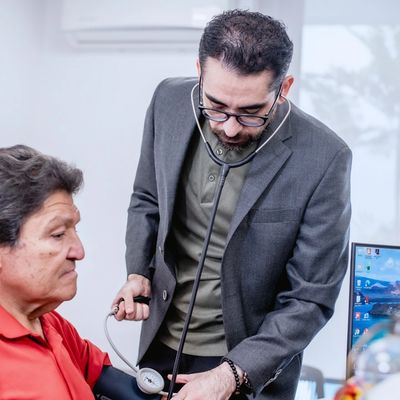 Doctor checking blood pressure of a male patient in a clinic.