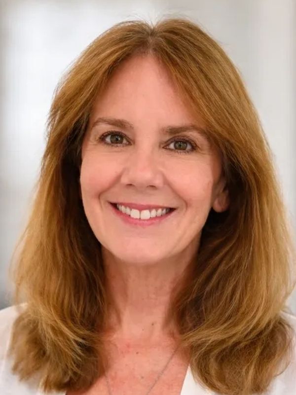Smiling middle-aged woman with shoulder-length light brown hair.