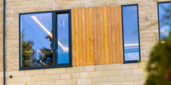 Modern building facade with large windows and wooden paneling.
