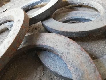Rusty metal rings scattered on a dusty surface.