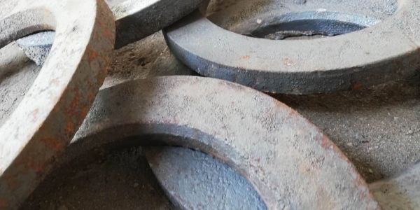 Rusty metal rings scattered on a dusty surface.