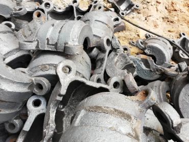 Pile of cast metal industrial parts with looped ends.