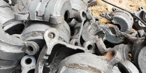 Pile of cast metal industrial parts with looped ends.