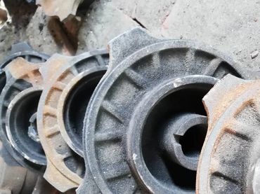 Stacked, rusty metal machine parts in a workshop or storage area.
