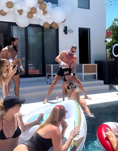 Shirtless bartender serves up a cold drink poolside in Miami