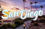 san diego california white bold letters. two thin palm trees in front, a sunset + ocean view behind